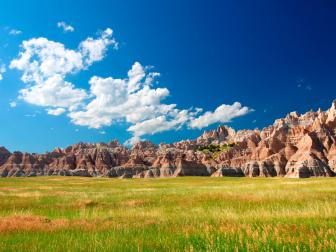 Windswept prairies below jagged mountains in Badands National Park of South Dakota.